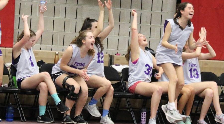 Team members of the Kittens celebrate their lead after a three point shot, showing the joy that comes with every church league basketball game.