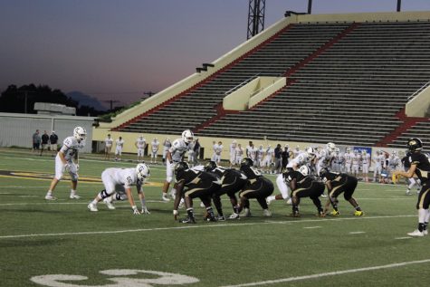 The football team's offensive line gathers at scrimmage line for a play against Bentonville West.