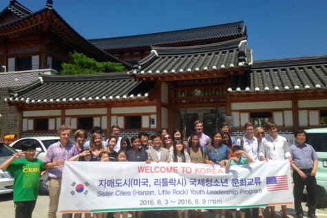 Students and chaperones pose in front of a traditional Korean restaurant.