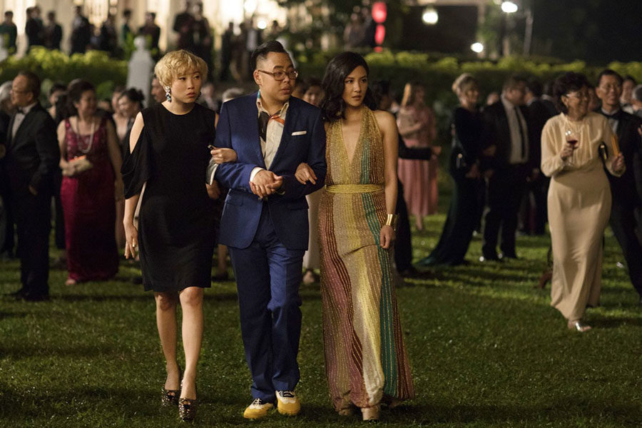 (From left) Awkwafina, Nico Santos, and Constance Wu walk arm in arm at a party at Wus characters boyfriends grandmas house, setting the scene for the rest of the movie. (photo courtesy of the Inquirer)