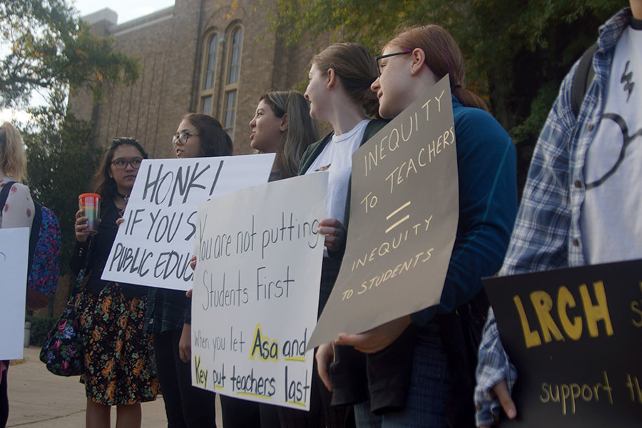 (From left) Seniors Lizzie Hutson, Hope Snyder, Salma Abdullrahman, Annie Simon, and Keira Boop show their support for teachers through homemade signs portraying the current issues with the public education system. (photo by Lola Simmons)