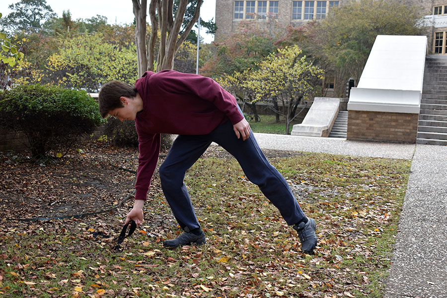 Junior Dillon Simmons leader of the Trail Blazers club at Central, leans over to pick up a piece of trash on their project to clean up our school campus. (photo by Gage Maris)