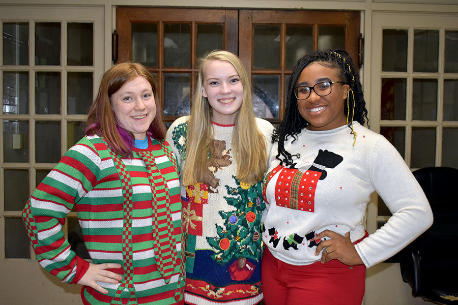 (Left to Right) senior Kiera Boop, Kennedy Kasten, and Briania Fleming take time out of AP Lit to show of their bright and colorful ugly sweaters. (photo by Parker Gunn)
