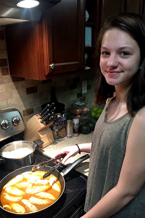 Sophomore Joelle Fahoum prepares dinner for her family. She cooks jerk chicken with seasonings as an international trest. (photo courtesy of Joelle Fahoum)