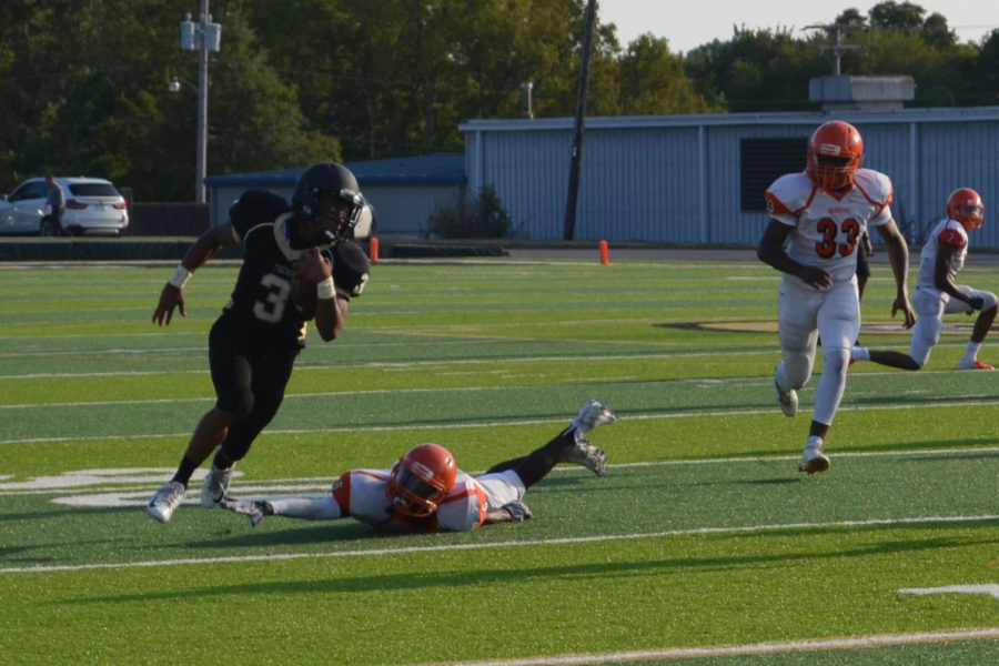 Senior Antoine Westbrook dodges a tackle from Hall Warrior and looks to score (photo by Annie Fortune). 