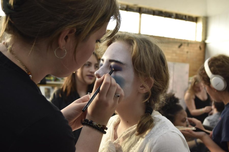 Heather Jennings helps Amelia Kerby with her stage makeup before the dress rehearsal Nov. 2. 