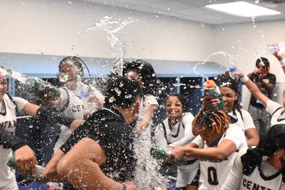 Coach Marlon Williams and the girls team celebrate their first ever state championship title in the locker room after the game. Photo by Meredith Lipsey