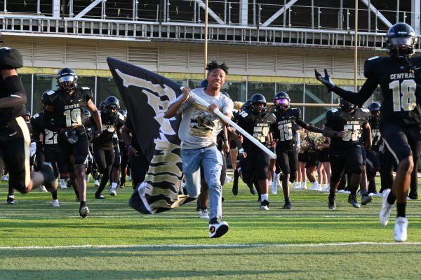 Senior, Jaden Carter leads football players onto the field to play the opening scrimmage against Jacksonville. The team won 9-0 Aug. 23. 
Photo by Chloe White