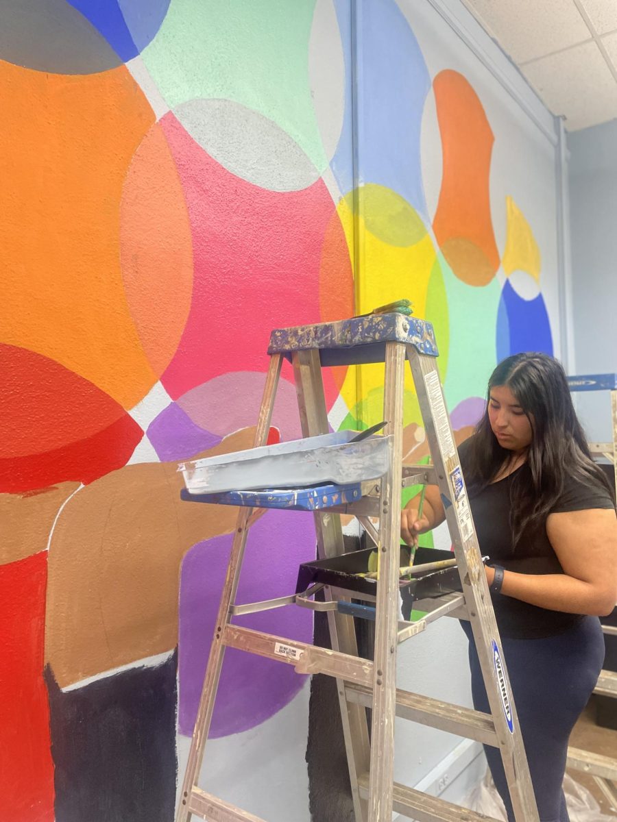 Senior Kayla Jimenez helps paint the mural in Ms. Walls' classroom on Monday, Aug. 26. 
