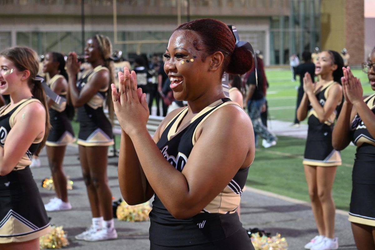 Cheer captain senior Autumn Booth leads her team with a smile during the game against Springdale, Aug 22.