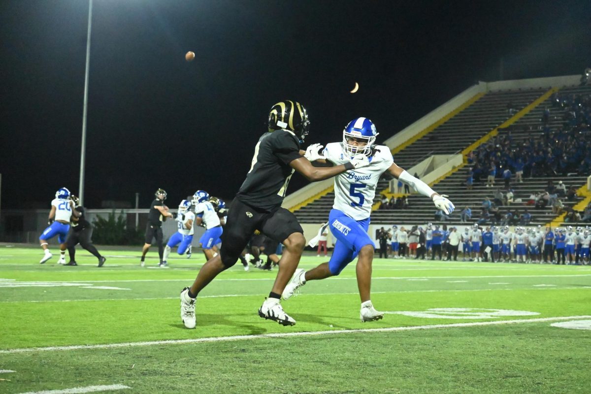 Football receiver pushes past Bryant defender while running for a catch Sept. 29.