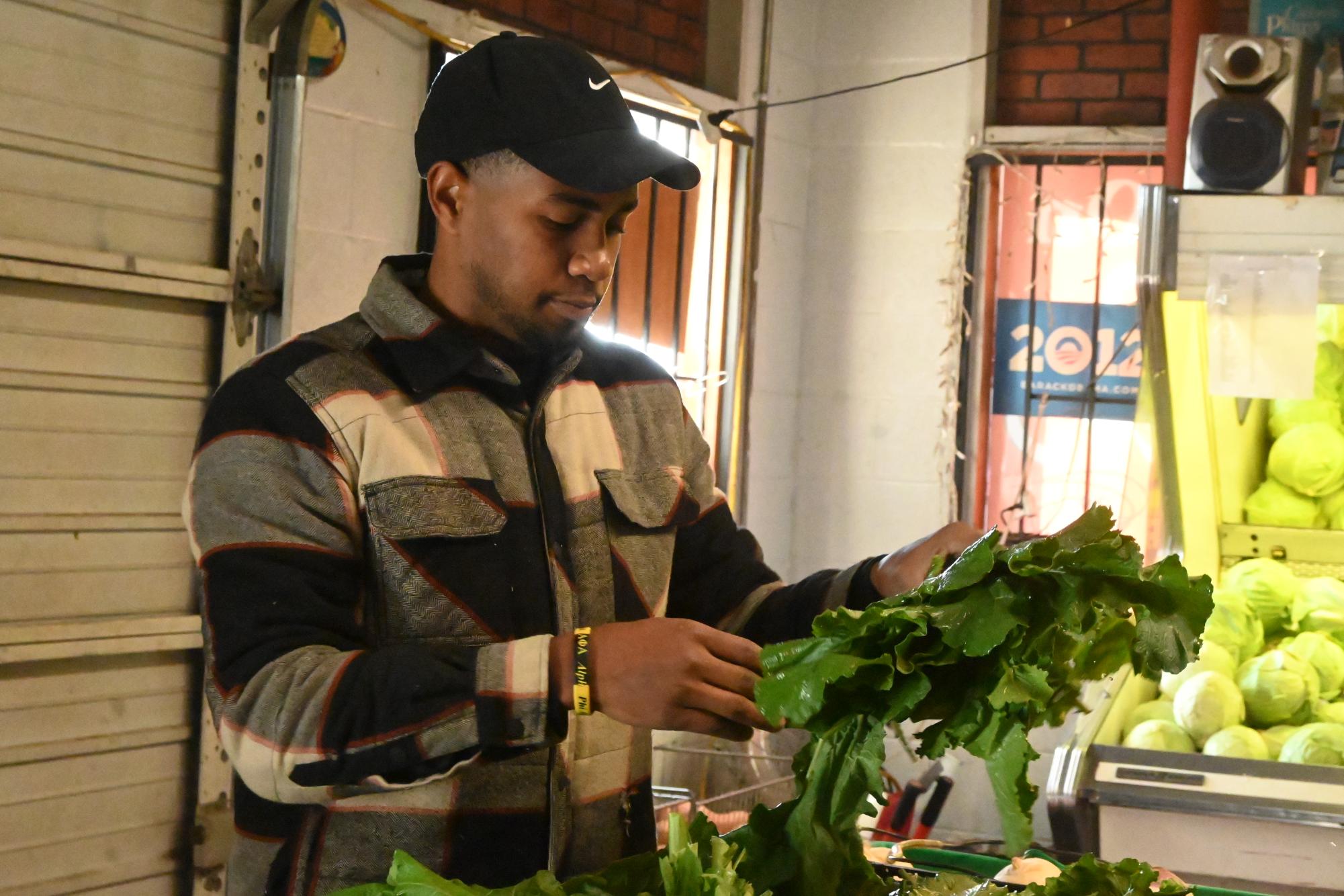 Devin Hall displays K-Hall’s fresh
produce and prepares the store to open
for the day Nov. 9.