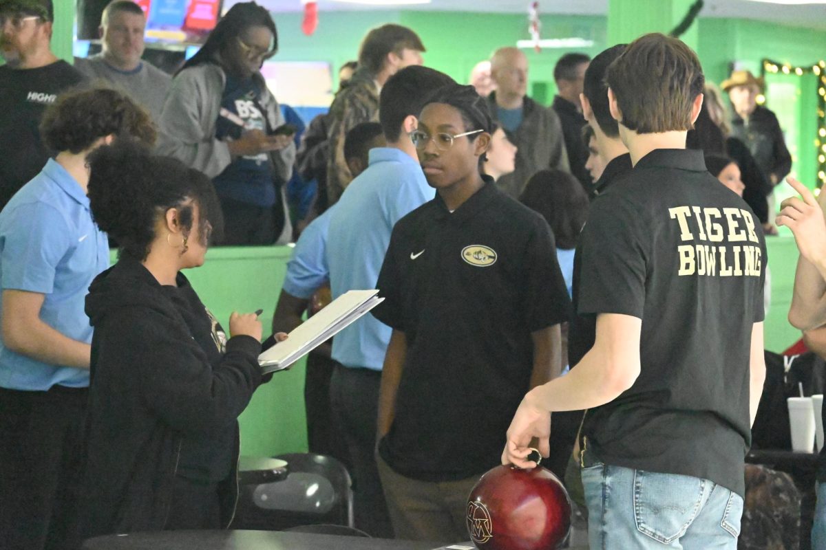 Coach Alundra Dickson speaks to freshman Iverson Ellington during a bowling match against North Little Rock.