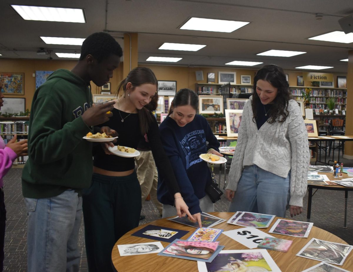 Juniors Lanphia Tarawally, Emery Johnson, Sadie Elson and Giorgia Hart take a look at some of the art featured at the annual Holiday Art Sale on Friday, Dec. 12, 2025.