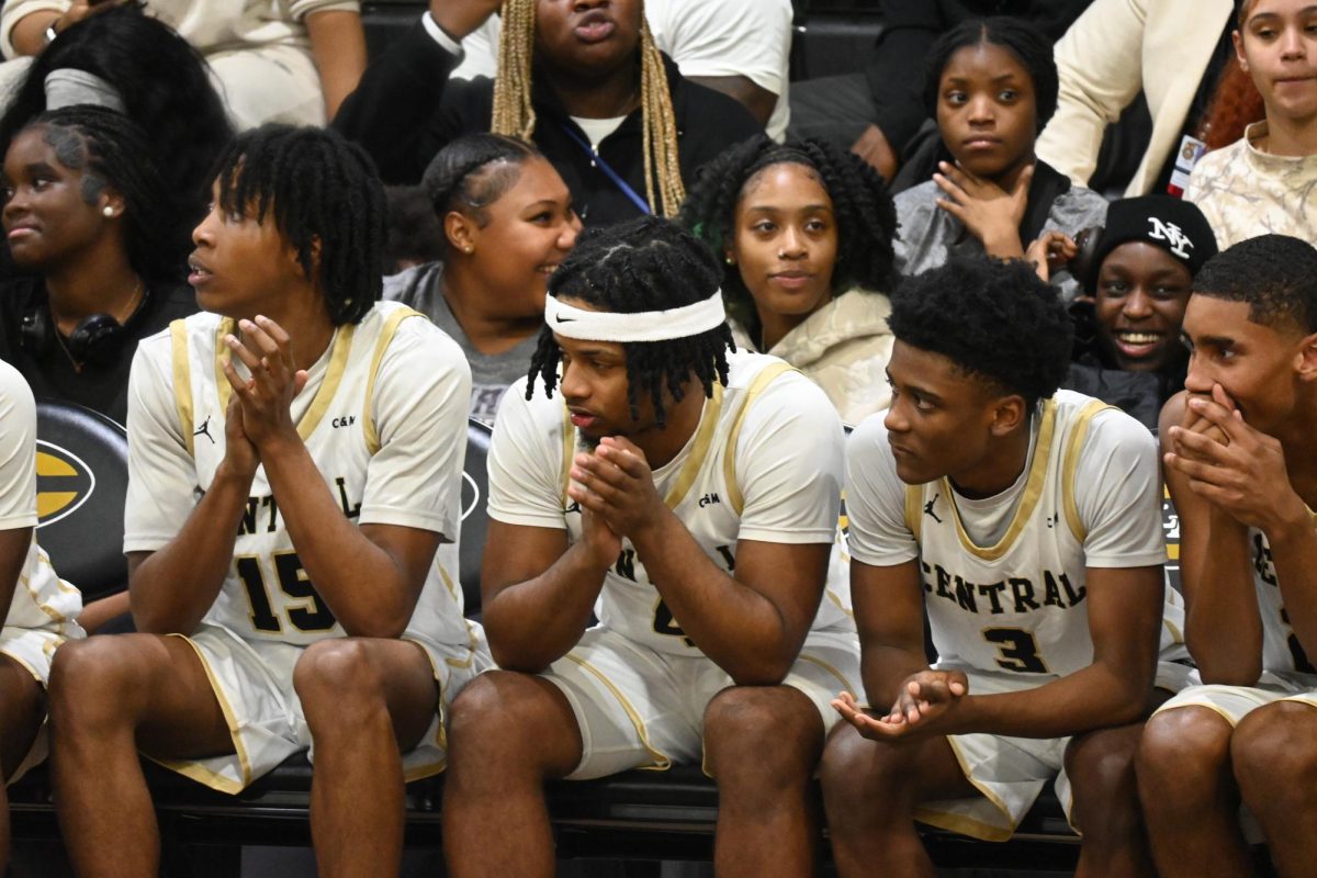 Terris Jones (junior), Jacob Marshall (senior), Shamod Cheeter (junior), and Jordan Slaughter (sophomore) cheer on their team during the "Black Out" themed game Jan. 13.