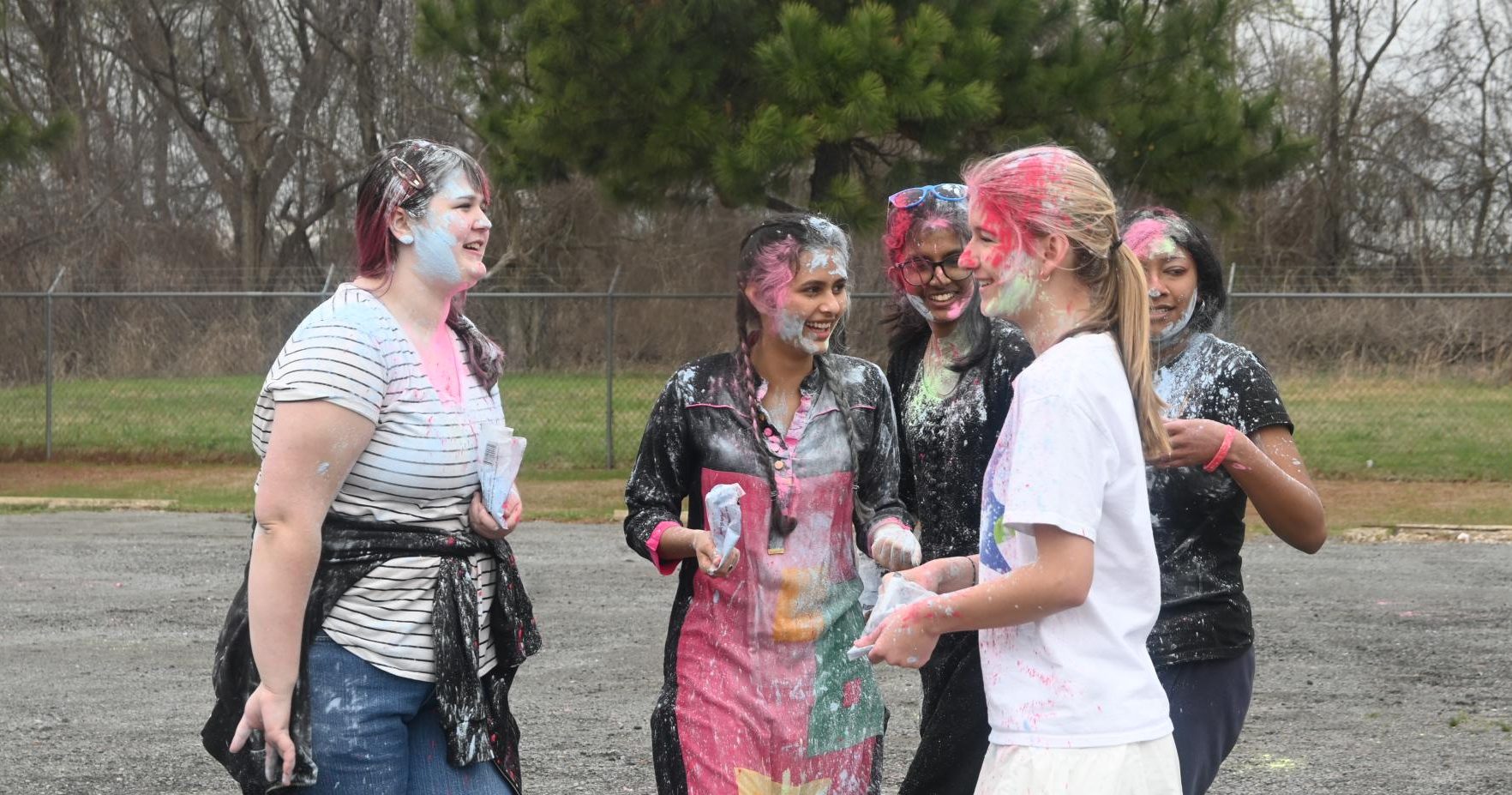Juniors Rose Matheny, Prisha Tiwari, Dharuna Chandramohan, and Helen Ferguson share smiles after throwing powder at one another March 6.