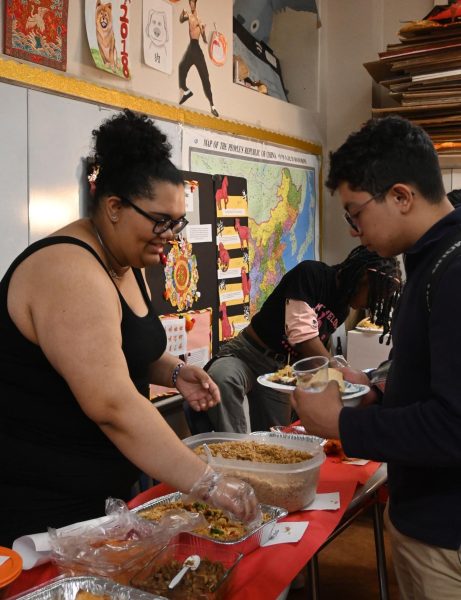 Sophomore Jose Mijangos fills his plate fried rice from the Chinese classroom during 80 Bites, March 18.